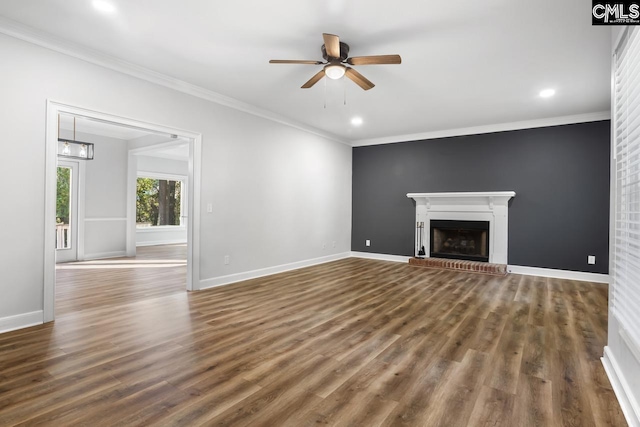 unfurnished living room featuring crown molding, ceiling fan, dark hardwood / wood-style floors, and a brick fireplace