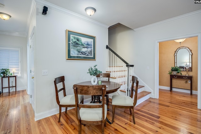 dining area featuring light hardwood / wood-style flooring and ornamental molding