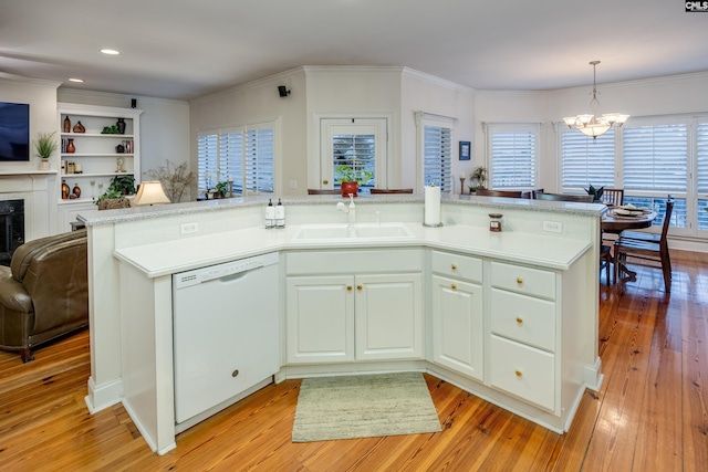 kitchen featuring decorative light fixtures, white cabinetry, sink, white dishwasher, and an inviting chandelier