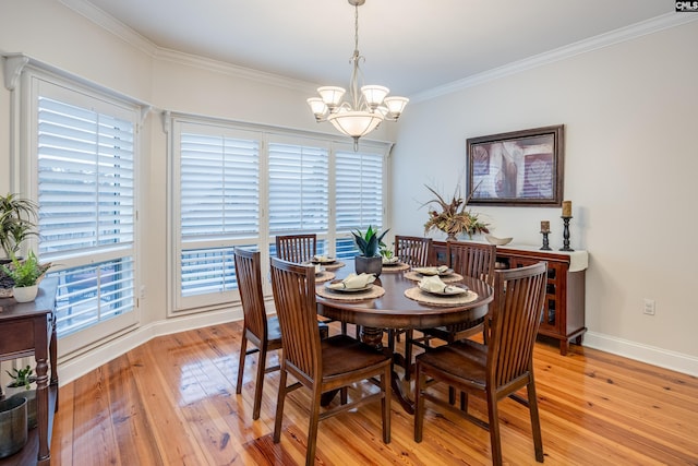 dining room featuring ornamental molding, a notable chandelier, and light hardwood / wood-style flooring