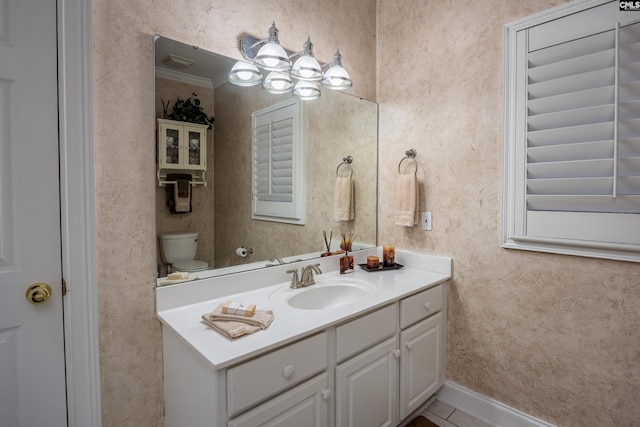 bathroom with crown molding, vanity, and toilet