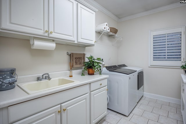 laundry area featuring light tile patterned flooring, washer and dryer, sink, cabinets, and crown molding