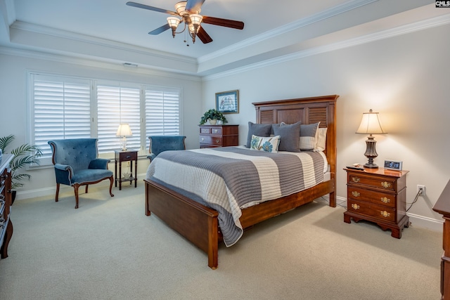 bedroom with light carpet, a tray ceiling, ornamental molding, and ceiling fan