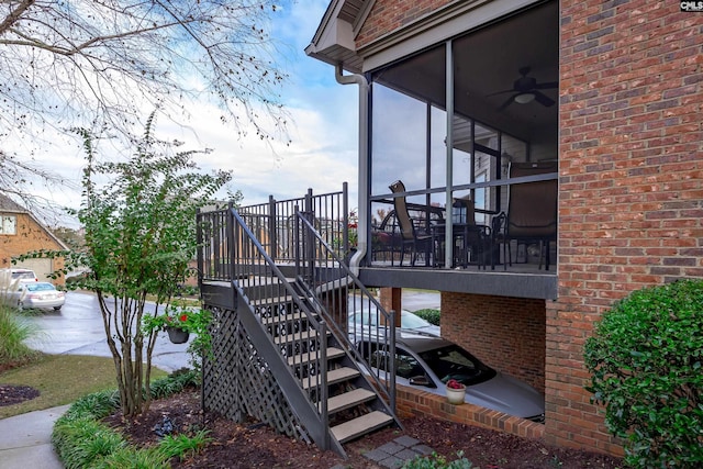 view of property exterior featuring a wooden deck, a sunroom, and ceiling fan