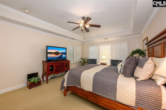 carpeted bedroom featuring ceiling fan, ornamental molding, and a tray ceiling