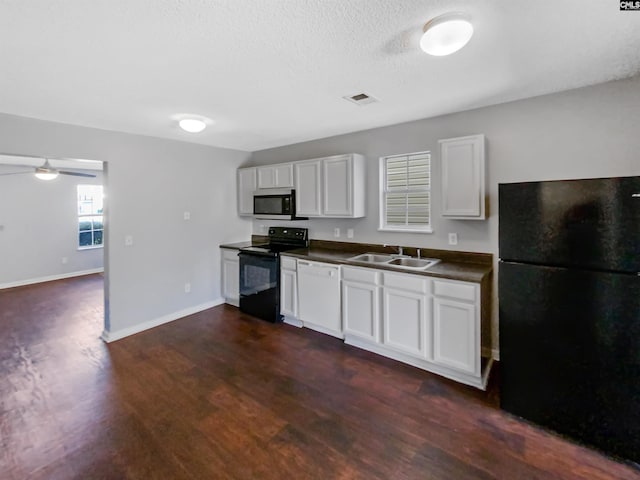 kitchen with black appliances, dark hardwood / wood-style flooring, white cabinets, and sink