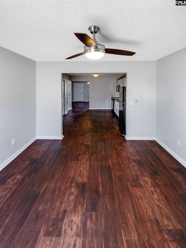 unfurnished living room with a textured ceiling, ceiling fan, and dark wood-type flooring