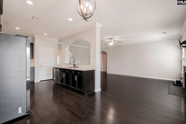 kitchen with dark wood-type flooring, stainless steel appliances, ceiling fan with notable chandelier, and sink