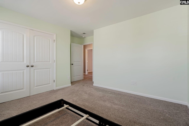 unfurnished bedroom featuring carpet flooring and a closet