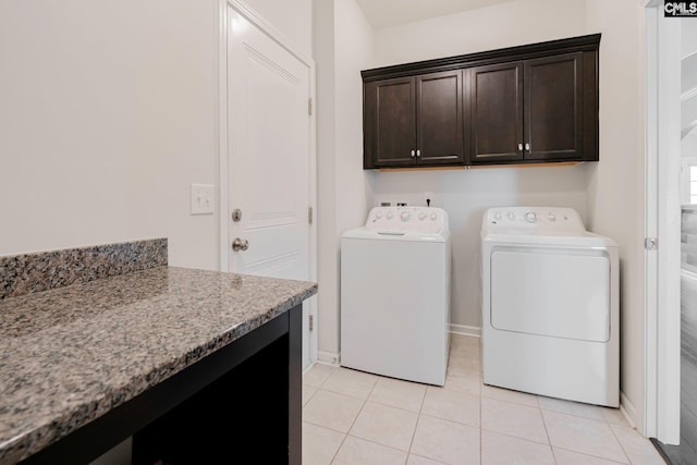 clothes washing area with light tile patterned flooring, cabinets, and separate washer and dryer