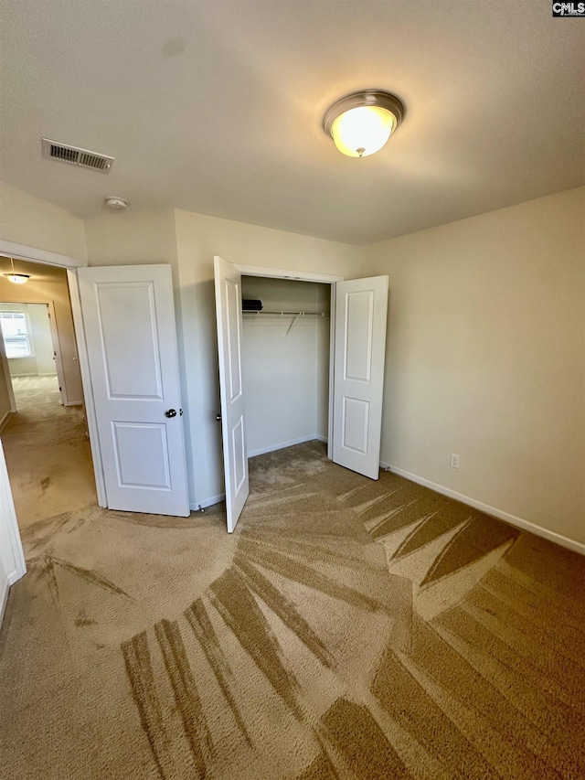 unfurnished bedroom featuring carpet and a closet