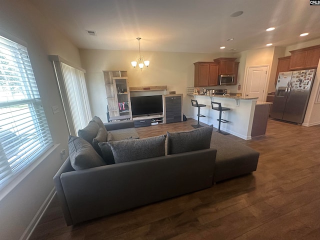 living room featuring a chandelier and dark wood-type flooring