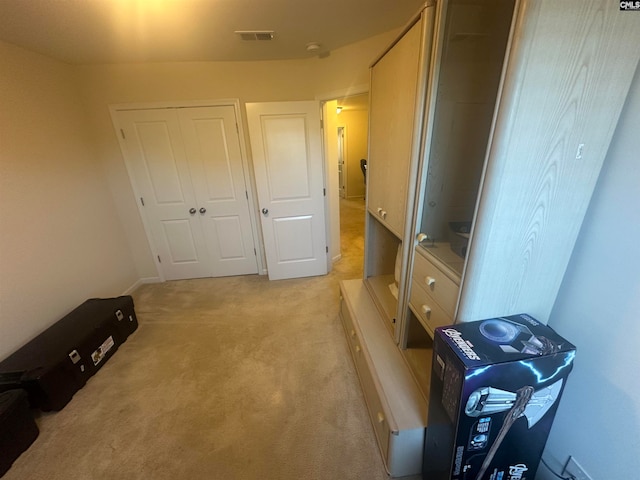 unfurnished bedroom featuring light carpet and a closet