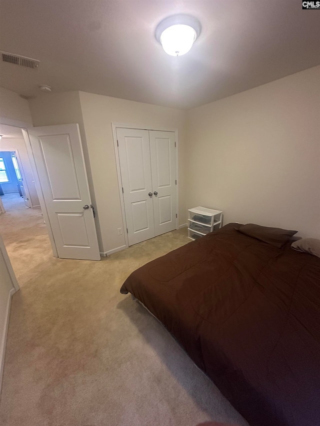 bedroom featuring light colored carpet and a closet