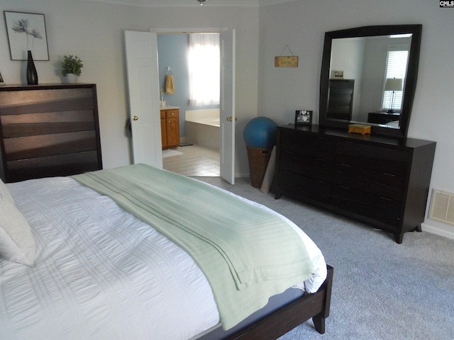 bedroom with light carpet and ensuite bathroom