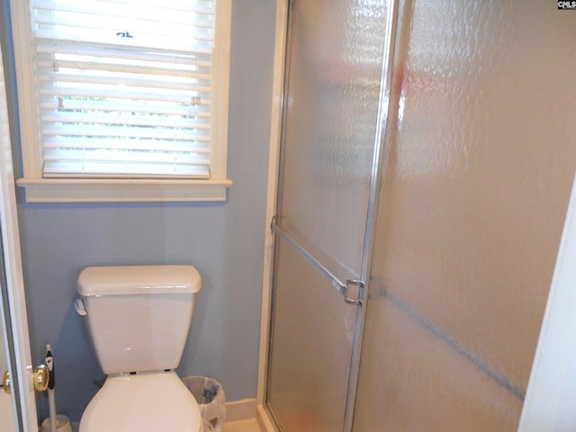 bathroom with toilet and a shower with shower door