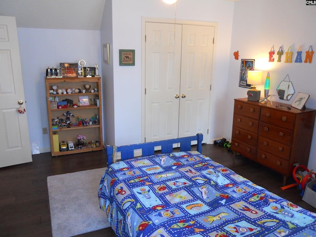 bedroom with lofted ceiling, dark wood-type flooring, and a closet