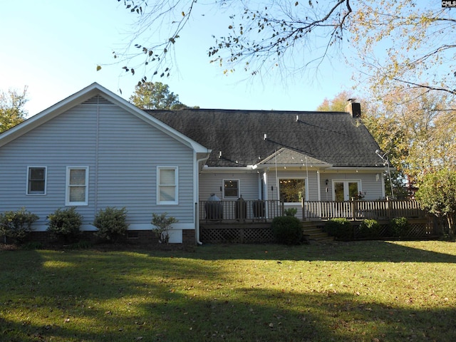 back of property with a yard and a deck