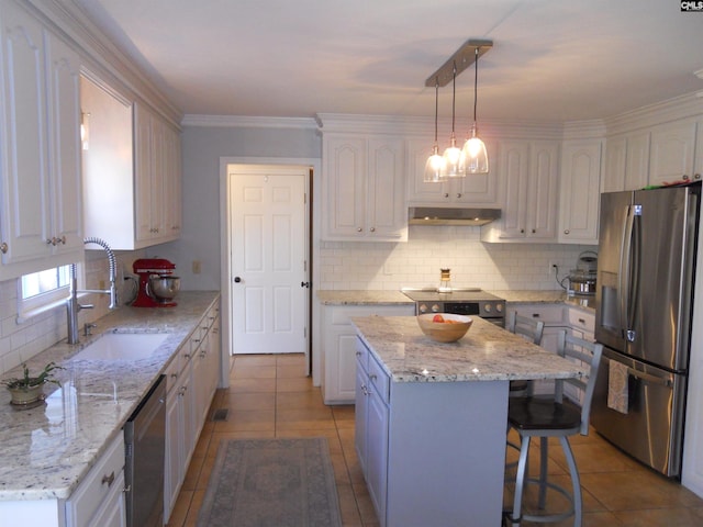 kitchen with white cabinets, appliances with stainless steel finishes, a center island, and decorative light fixtures