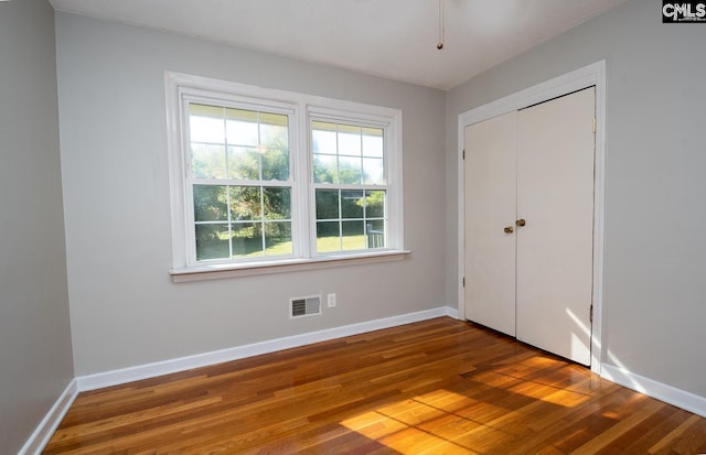 unfurnished bedroom with wood-type flooring and a closet