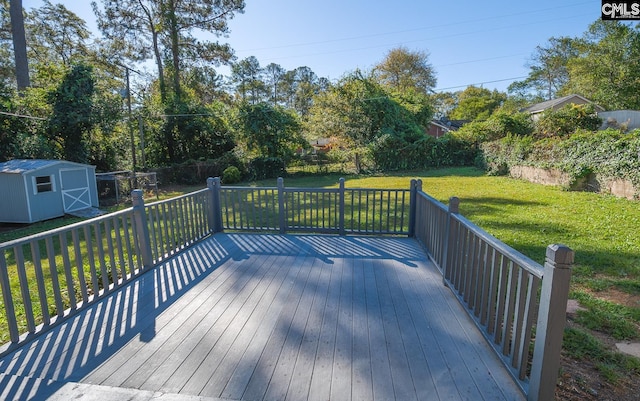 wooden terrace with a lawn and a storage shed