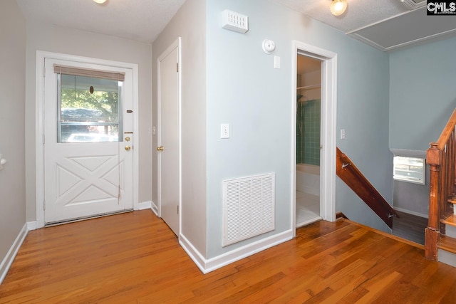 entryway featuring light wood-type flooring and a textured ceiling