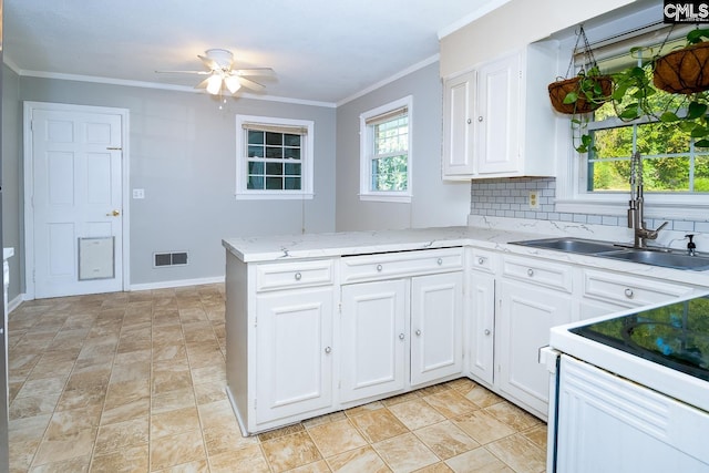 kitchen featuring ceiling fan, white cabinetry, kitchen peninsula, and backsplash