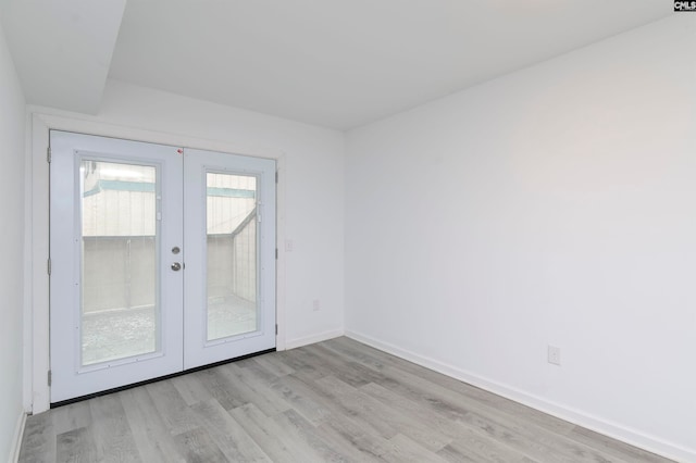 unfurnished room featuring french doors and light wood-type flooring