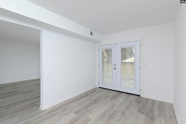 unfurnished room with light hardwood / wood-style floors and french doors