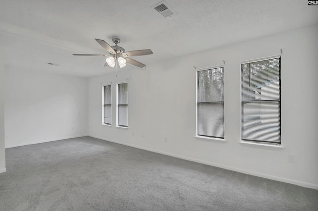 spare room featuring ceiling fan, a healthy amount of sunlight, and carpet floors