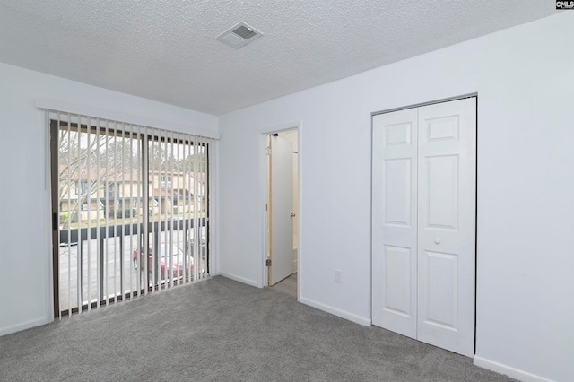 unfurnished bedroom with a closet, carpet floors, and a textured ceiling