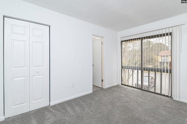 unfurnished bedroom featuring a closet, carpet, and a textured ceiling