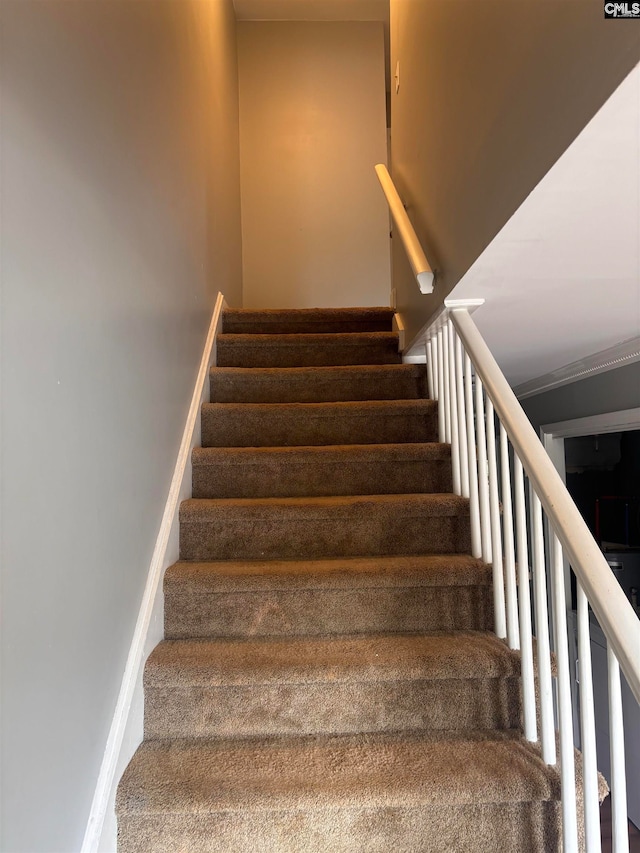 stairs featuring crown molding