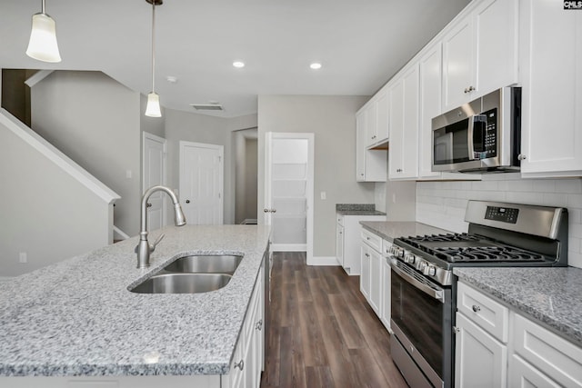 kitchen with pendant lighting, white cabinets, sink, dark hardwood / wood-style flooring, and stainless steel appliances