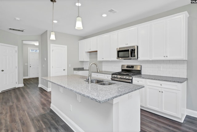 kitchen with pendant lighting, an island with sink, stainless steel appliances, and sink