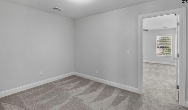 unfurnished room featuring light colored carpet