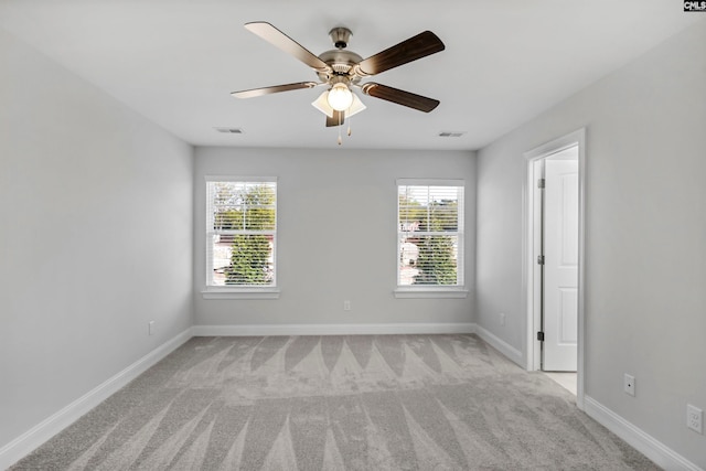 carpeted spare room with a wealth of natural light and ceiling fan