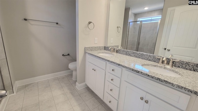 bathroom featuring tile patterned floors, vanity, toilet, and a shower with shower door