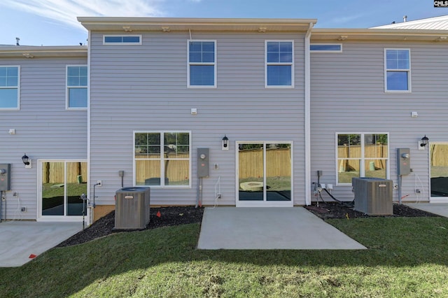 rear view of property featuring a yard, a patio, and central air condition unit