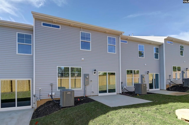 back of property featuring central AC unit, a patio, and a lawn