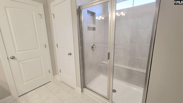 bathroom with tile patterned floors and a shower with door