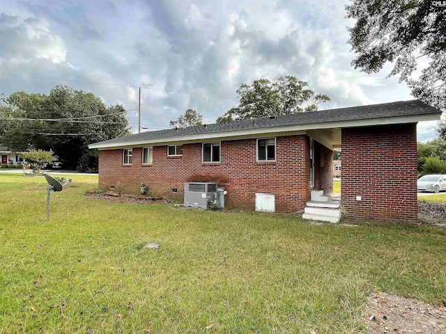 rear view of house with a yard and central AC