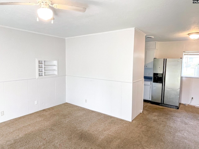 carpeted spare room featuring ceiling fan, crown molding, and a textured ceiling