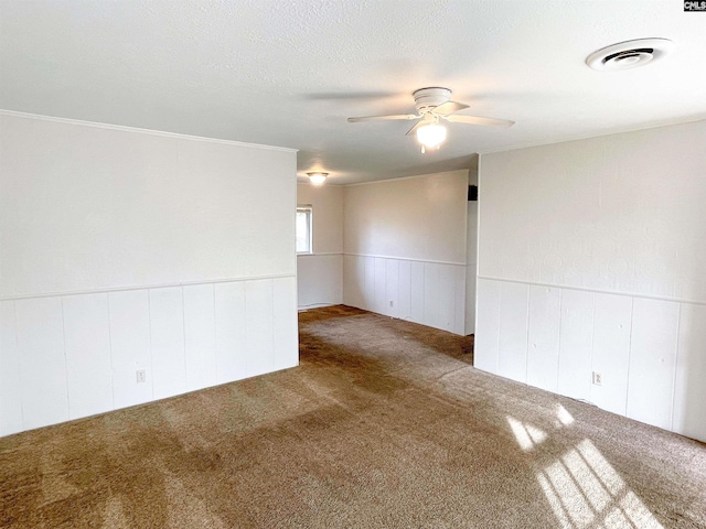 carpeted spare room with ceiling fan and a textured ceiling