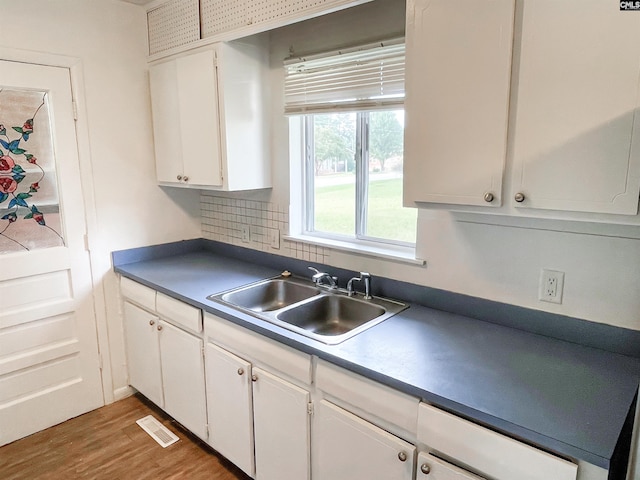 kitchen with white cabinets, backsplash, dark wood-type flooring, and sink