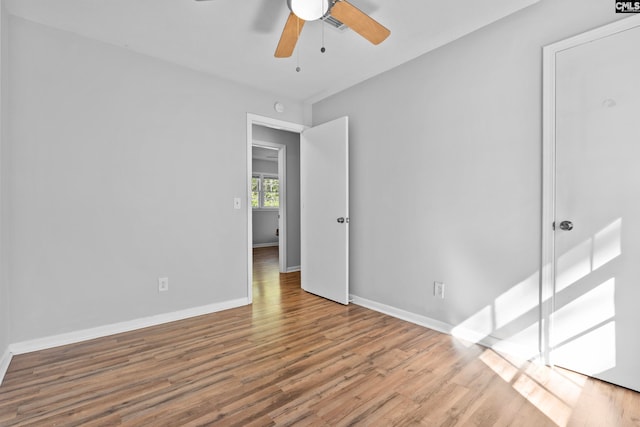 empty room with ceiling fan and light hardwood / wood-style floors