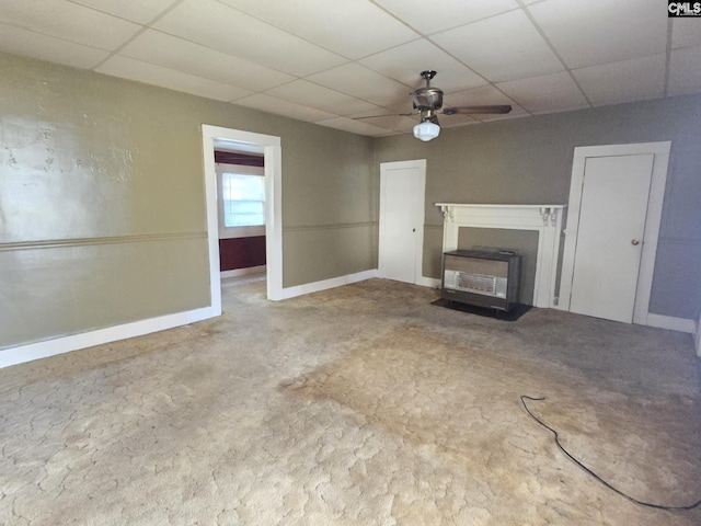 unfurnished living room featuring a drop ceiling and ceiling fan