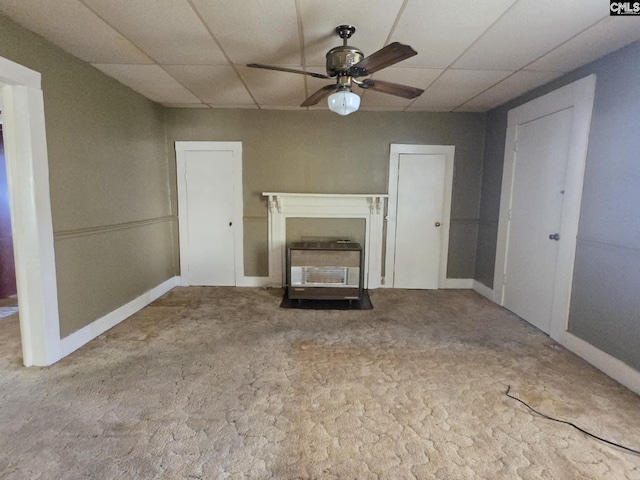 unfurnished living room with a paneled ceiling, ceiling fan, and carpet