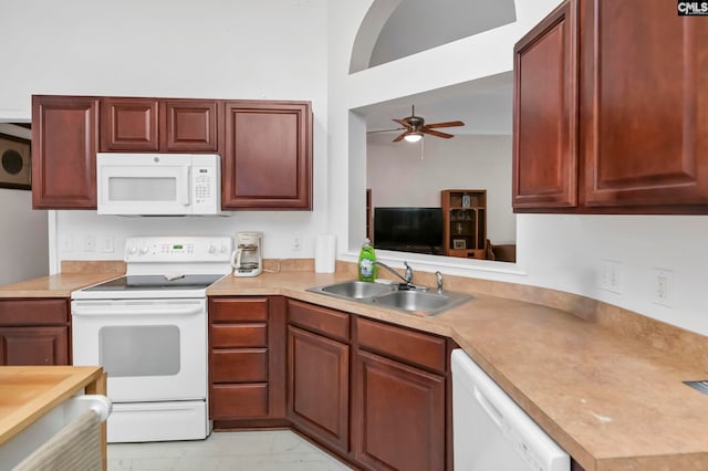 kitchen with a towering ceiling, white appliances, ceiling fan, and sink