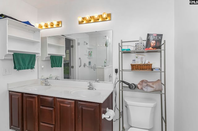 bathroom with vanity, toilet, and a shower with door